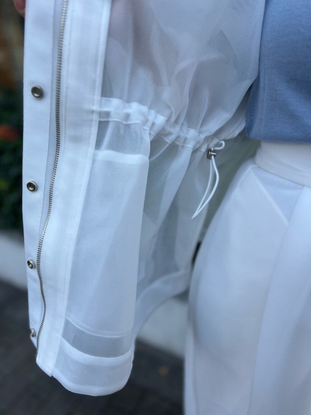 ホワイト系のその他アウター、ブルー系のニット/セーター、ホワイト系のスカートを着用したレディースの秋コーディネートの8枚目の写真