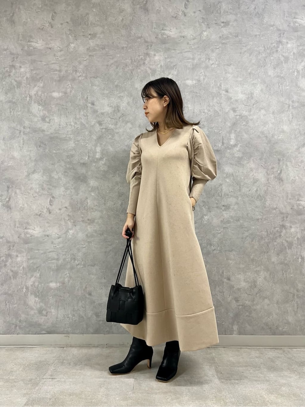 ブラック系のブーツ、ブラック系のカーディガン/ボレロ、ベージュ系のワンピースを着用したレディースの秋コーディネートの9枚目の写真