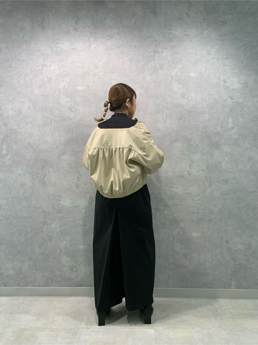 ブラック系のつなぎ/オールインワン、ブラウン系のブルゾン、ブラック系のブーツを着用したレディースの秋コーディネートの5枚目の写真