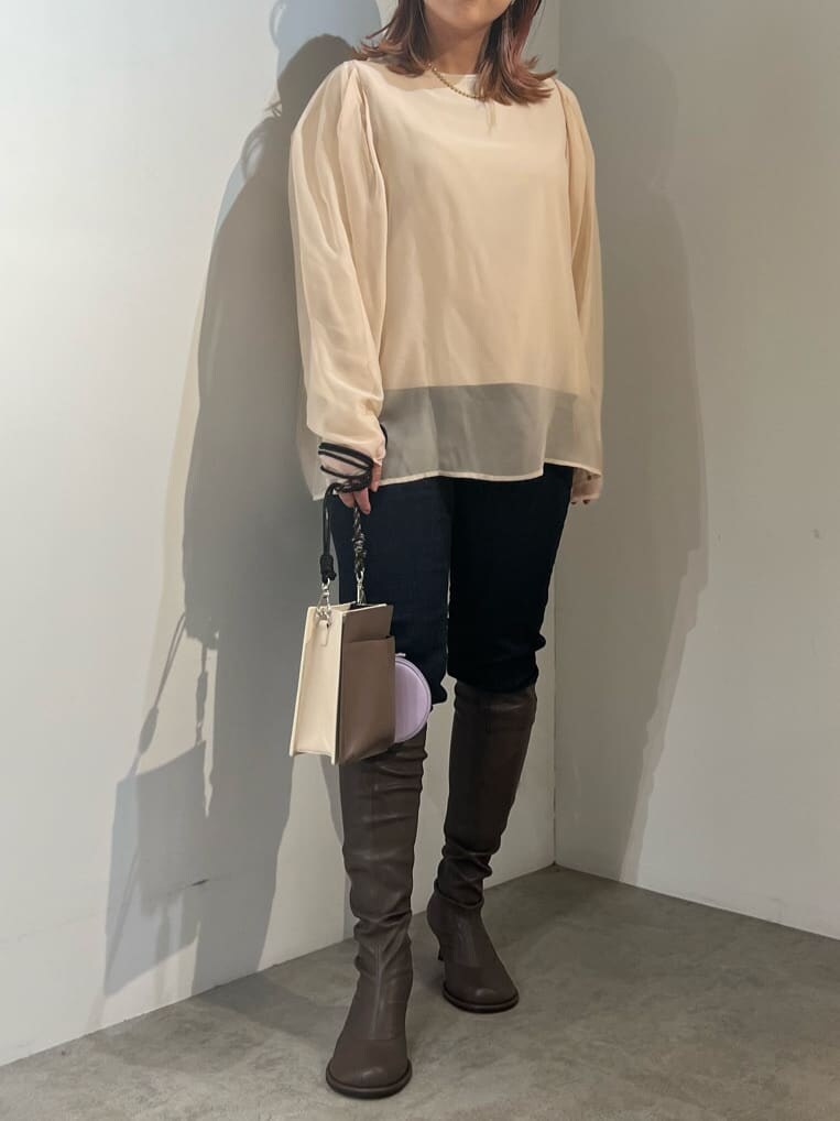 ブルー系のデニムパンツ、ベージュ系のショルダーバッグ、ブラウン系のニット/セーターを着用したレディースの秋コーディネートの3枚目の写真