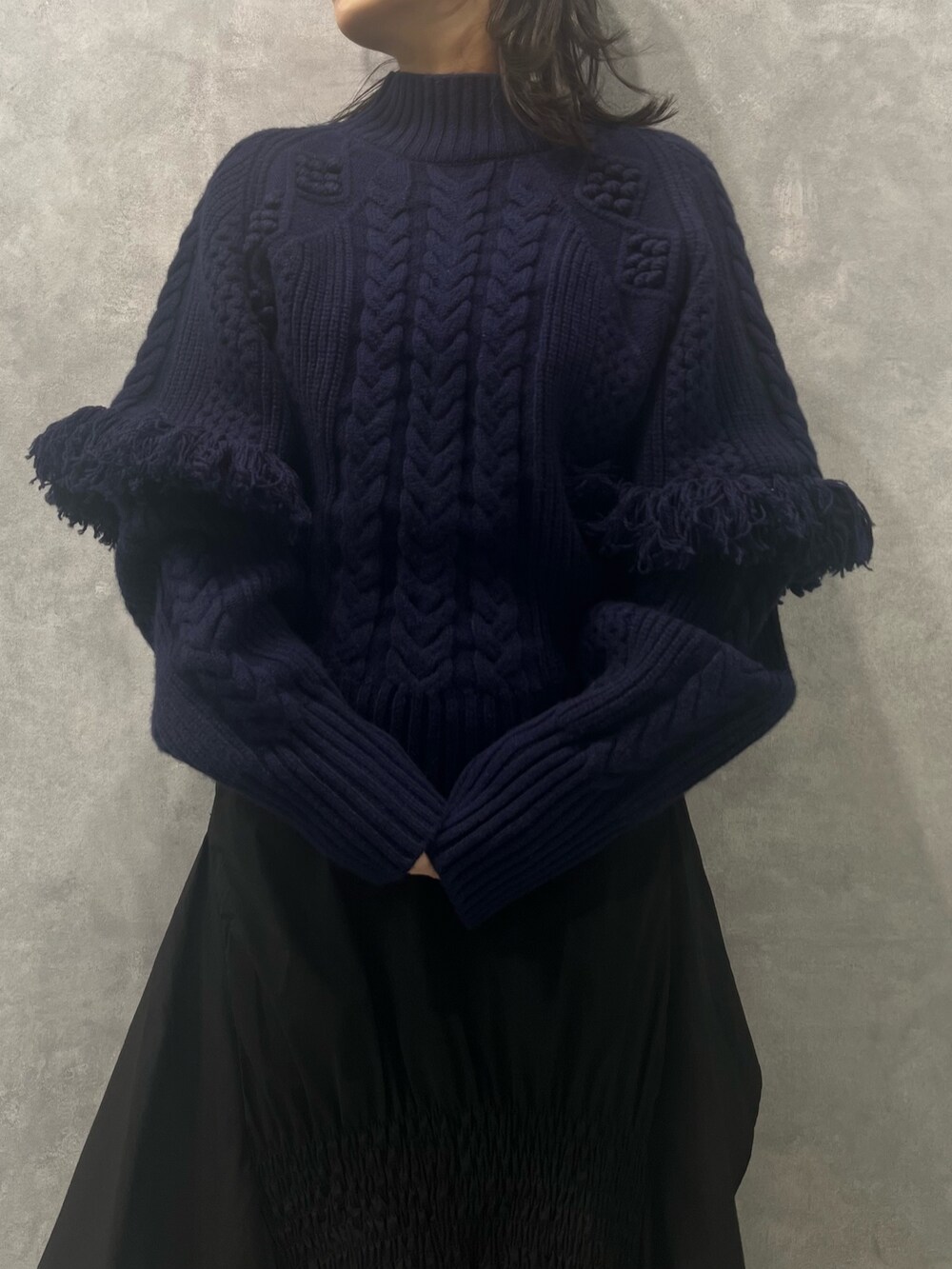 ブラック系のスカート、ブルー系のニット/セーターを着用したレディースの春コーディネートの3枚目の写真