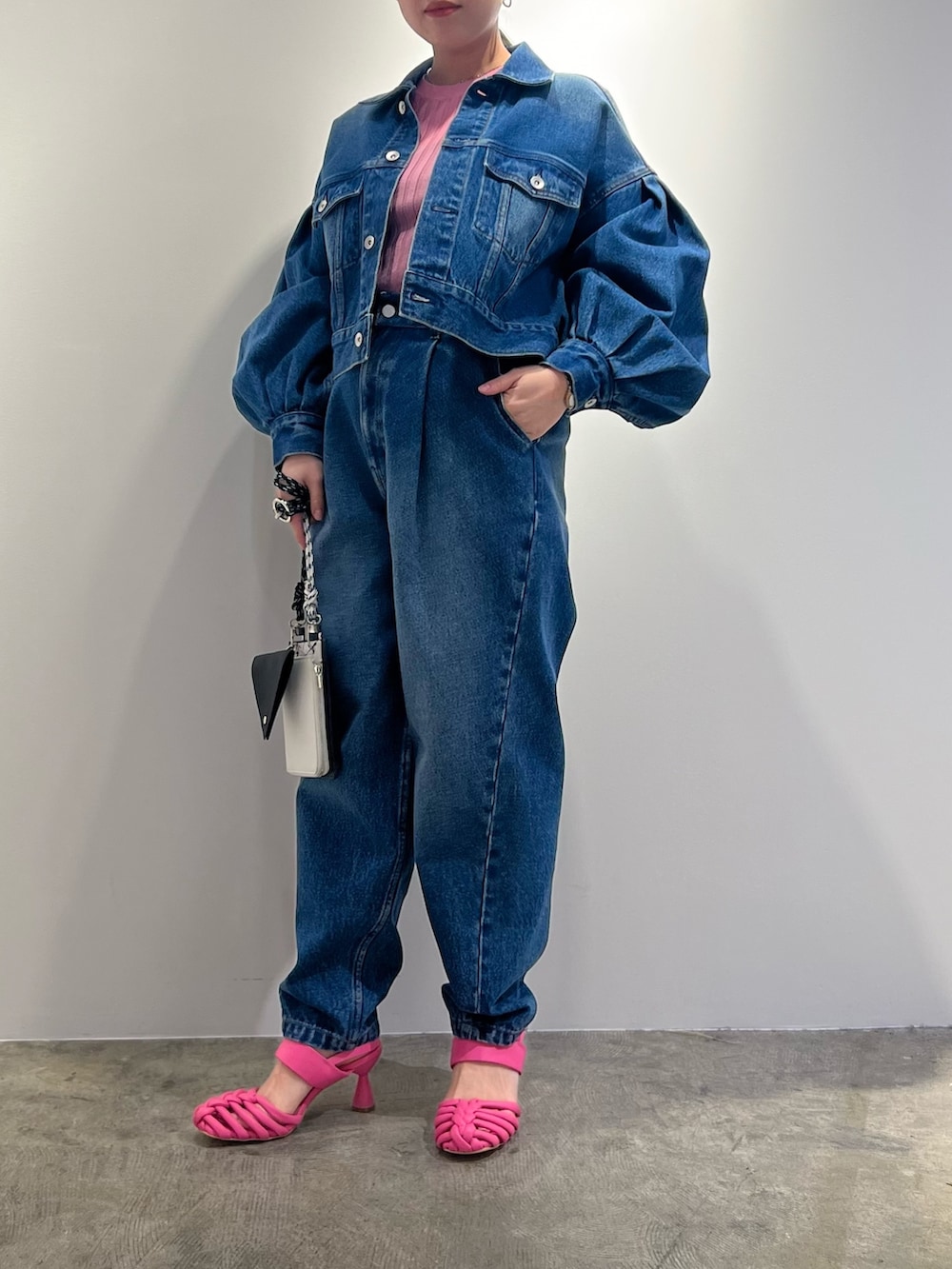 ブルー系のデニムジャケット、ブルー系のデニムパンツ、ブラック系のショルダーバッグを着用したレディースの冬コーディネートの2枚目の写真