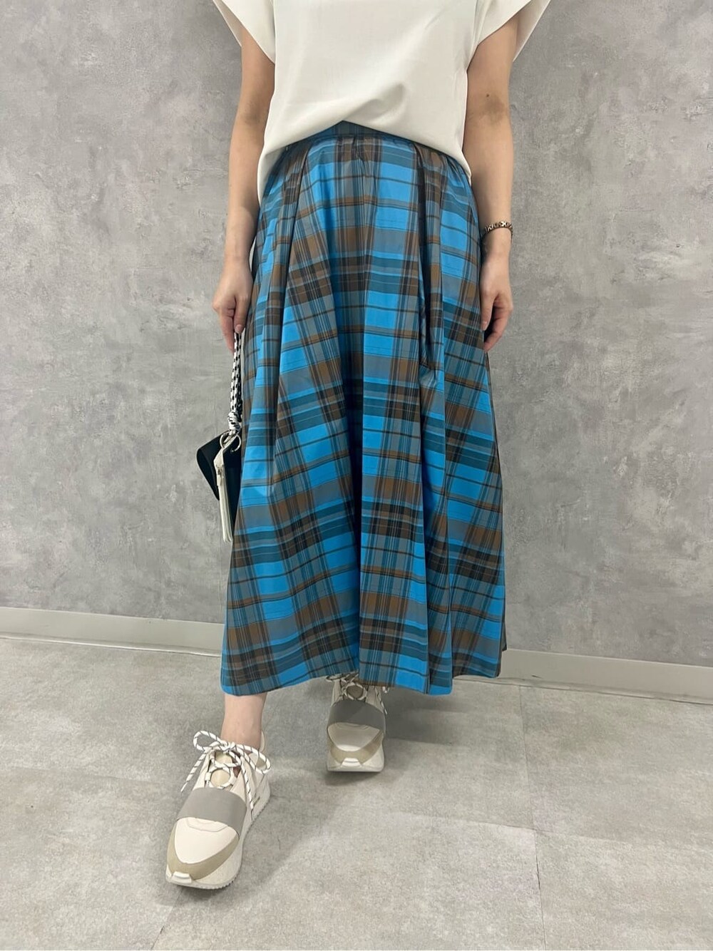 ブラック系のショルダーバッグ、ホワイト系のTシャツ/カットソー、その他のスカートを着用したレディースの夏コーディネートの4枚目の写真