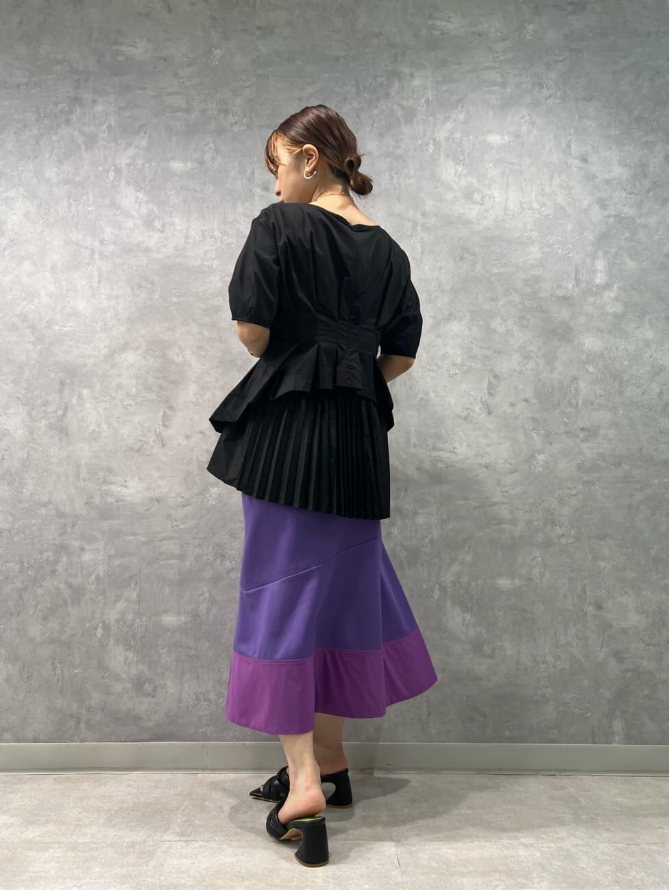 ブラック系のサンダル、パープル系のスカート、ブラック系のシャツ/ブラウスを着用したレディースの夏コーディネートの2枚目の写真