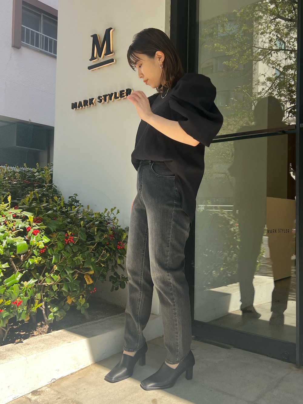 ブラック系のシャツ/ブラウス、グレー系のデニムパンツ、ブラック系のパンプスを着用したレディースの春コーディネートの4枚目の写真