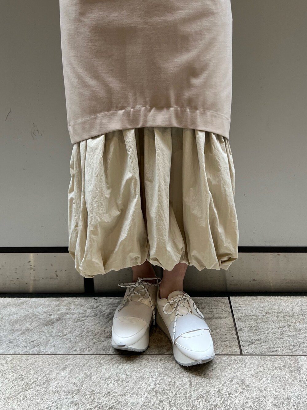 ベージュ系のワンピース、ホワイト系のスニーカー、ブラウン系のブルゾンを着用したレディースの春コーディネートの8枚目の写真
