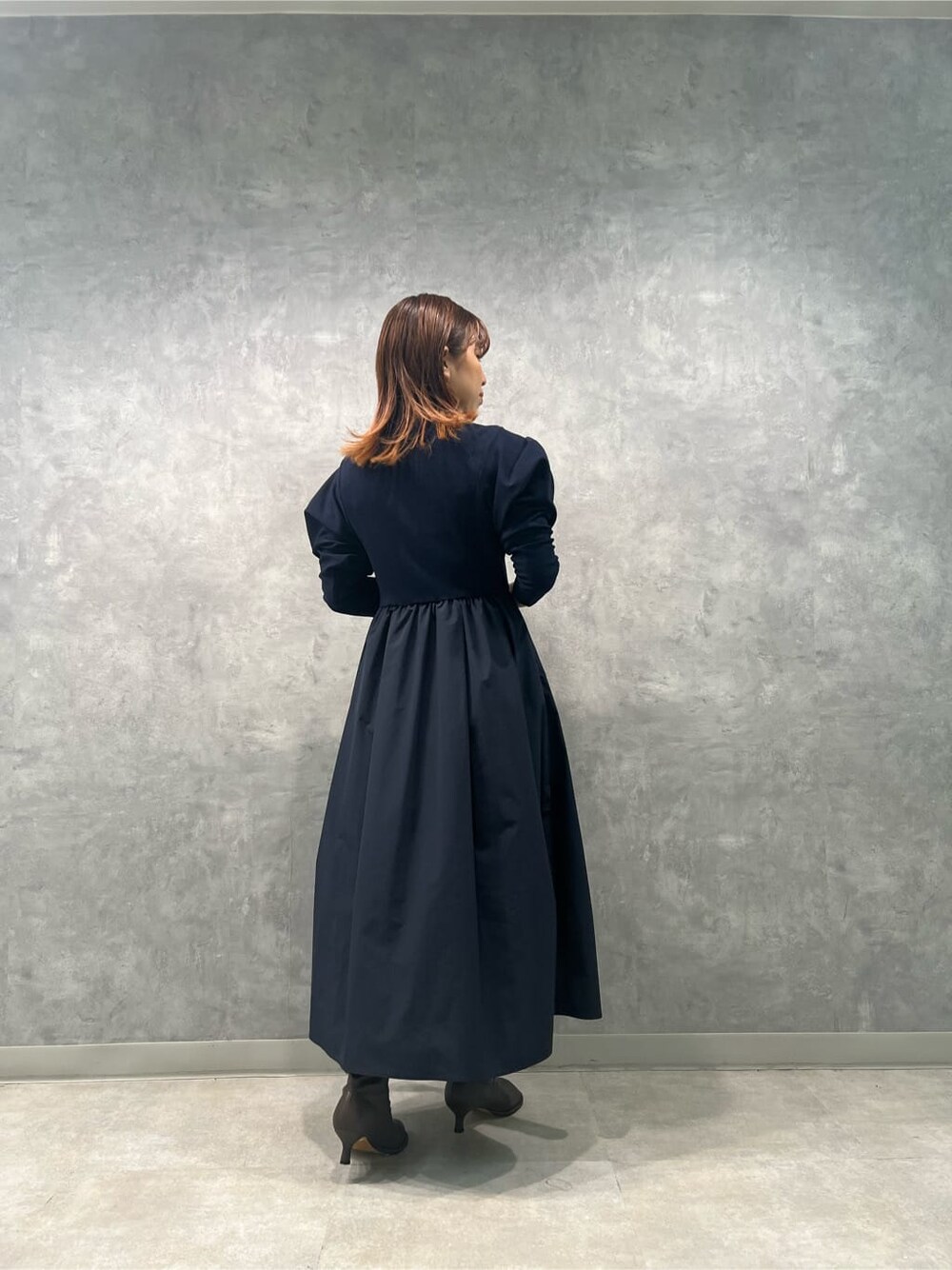 ブルー系のワンピースを着用したレディースの秋コーディネートの2枚目の写真