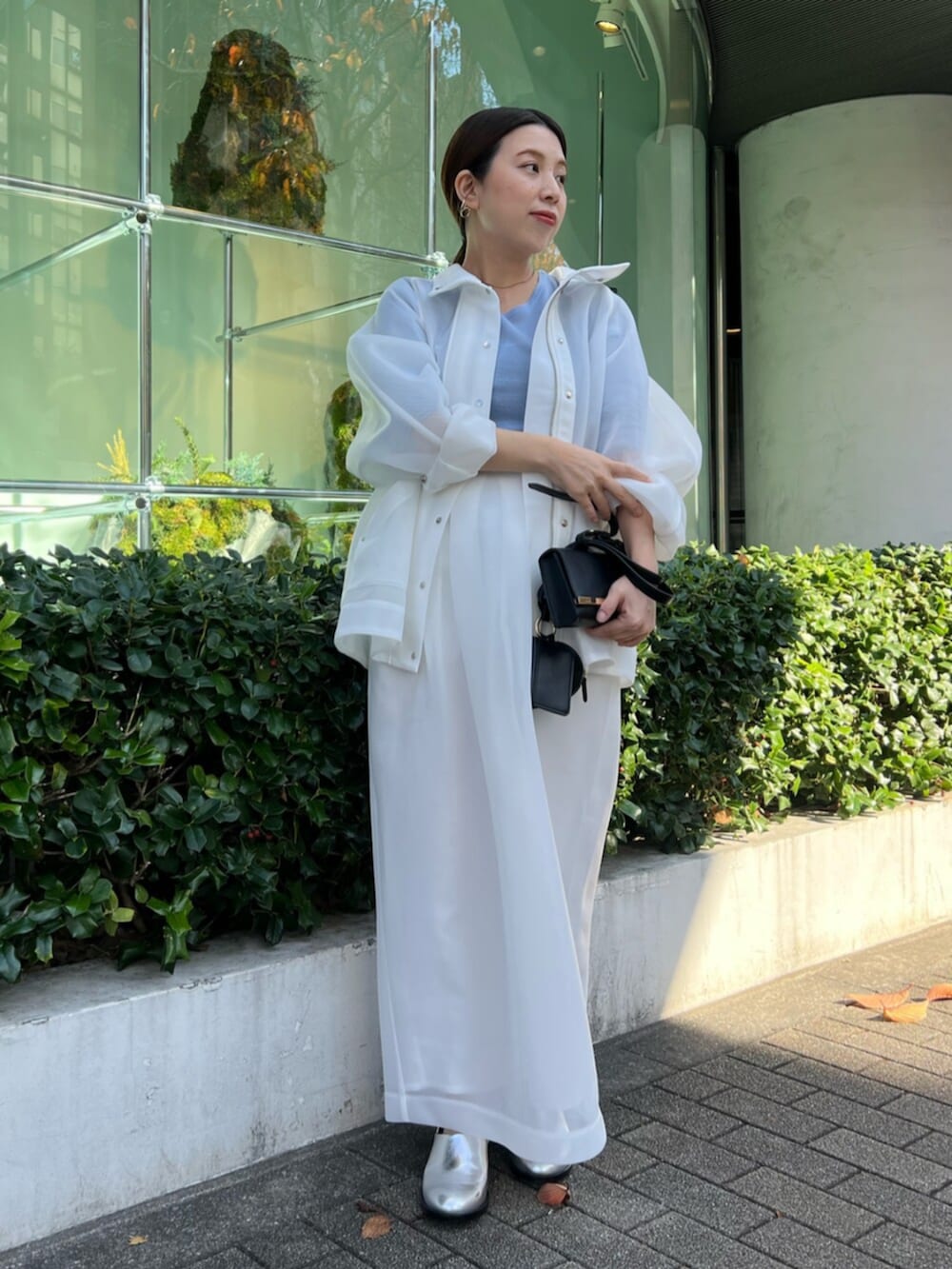 ホワイト系のその他アウター、ブルー系のニット/セーター、ホワイト系のスカートを着用したレディースの秋コーディネートの2枚目の写真