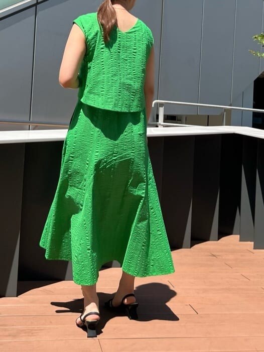 ブラック系のショルダーバッグ、グリーン系のワンピース、ブラック系のサンダルを着用したレディースの夏コーディネートの3枚目の写真