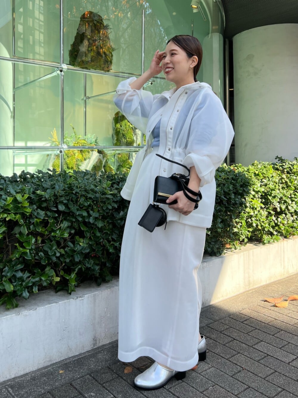 ホワイト系のその他アウター、ブルー系のニット/セーター、ホワイト系のスカートを着用したレディースの秋コーディネートの3枚目の写真