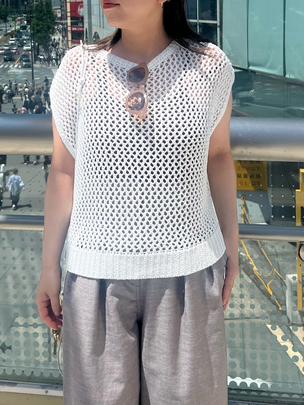 ホワイト系のニット/セーター、ブラウン系のその他パンツ、ホワイト系のショルダーバッグを着用したレディースの夏コーディネートの4枚目の写真