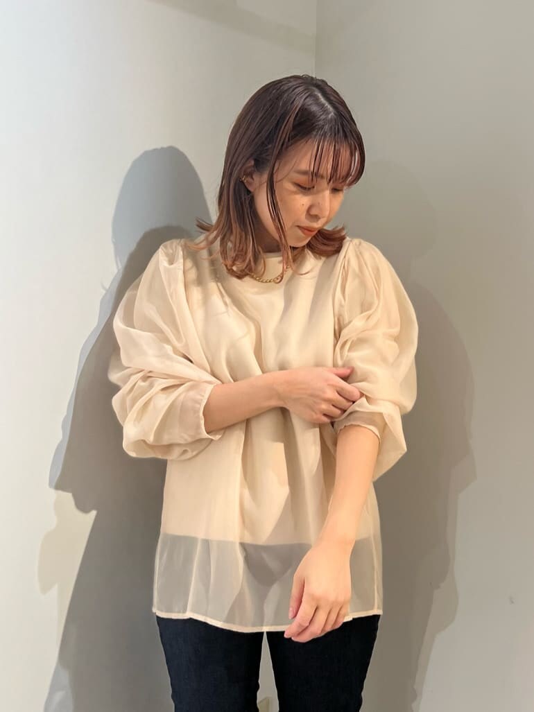 ブルー系のデニムパンツ、ベージュ系のショルダーバッグ、ブラウン系のニット/セーターを着用したレディースの秋コーディネートの6枚目の写真