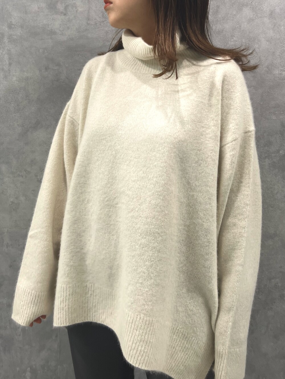 ホワイト系のニット/セーター、グレー系のその他パンツを着用したレディースの秋コーディネートの4枚目の写真