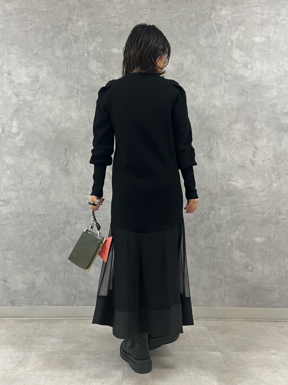 ブラック系のワンピース、ブルー系のデニムジャケット、ベージュ系のショルダーバッグを着用したレディースの冬コーディネートの6枚目の写真