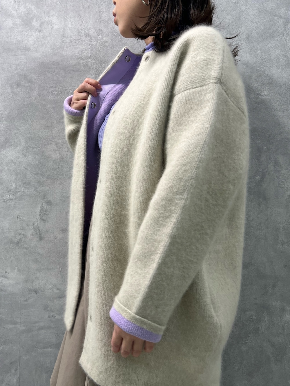 ホワイト系のノーカラージャケット、パープル系のニット/セーター、ベージュ系のスカートを着用したレディースの夏コーディネートの4枚目の写真