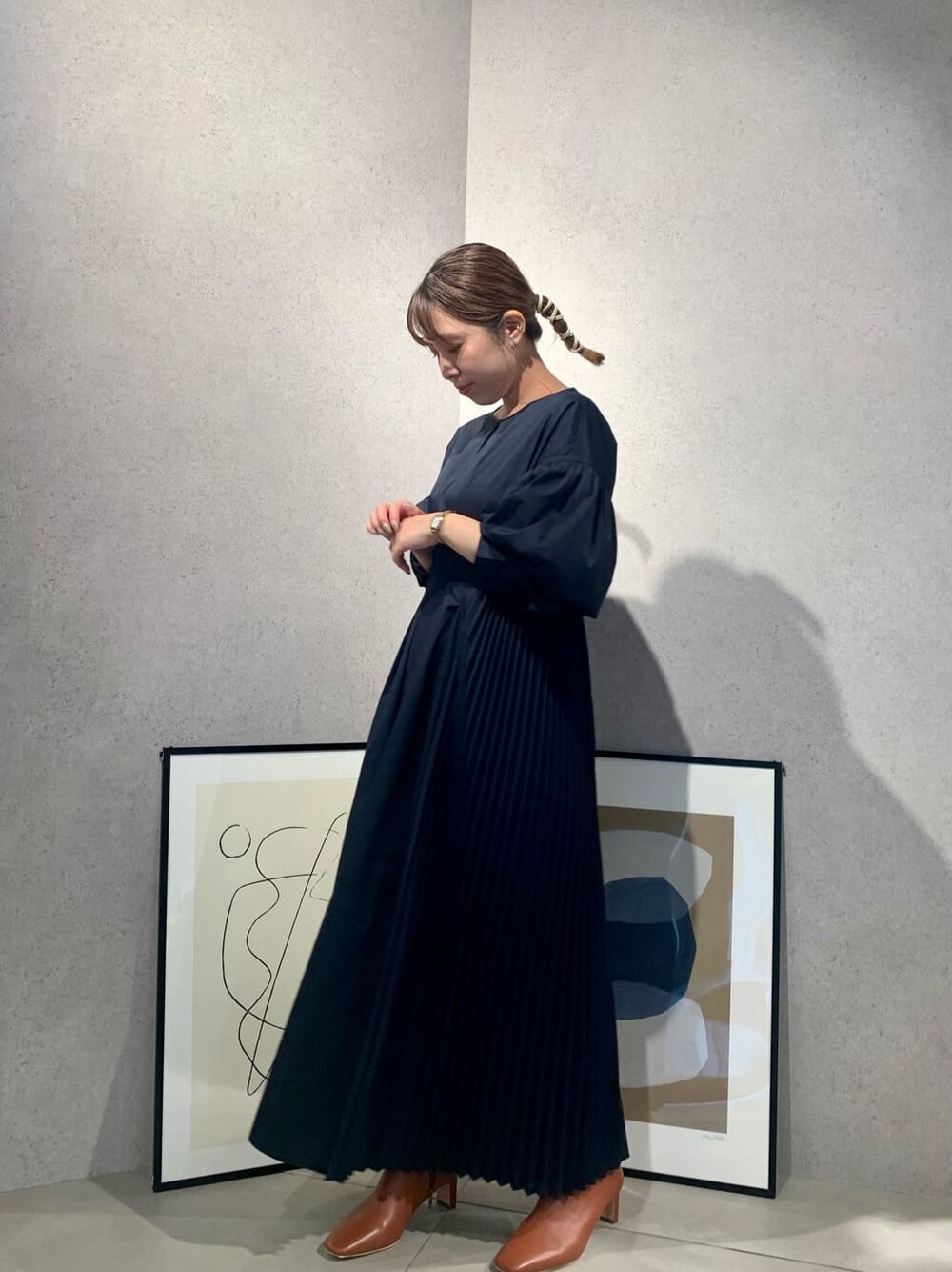 ブラウン系のショルダーバッグ、ブラック系のワンピース、ブラウン系のブーツを着用したレディースの夏コーディネートの7枚目の写真