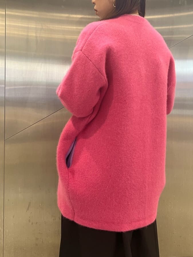 ピンク系のカーディガン/ボレロ、ブラック系のジャンパースカート、ホワイト系のニット/セーターを着用したレディースの夏コーディネートの4枚目の写真