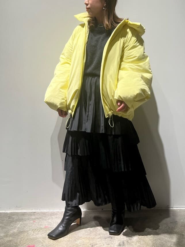 ブラック系のブーツ、イエロー系のダウンジャケット/コート、グレー系のニット/セーターを着用したレディースの秋コーディネートの3枚目の写真