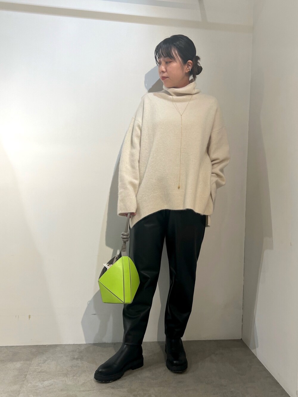 ブラック系のその他パンツ、ホワイト系のニット/セーター、グリーン系のチェスターコートを着用したレディースの冬コーディネートの4枚目の写真