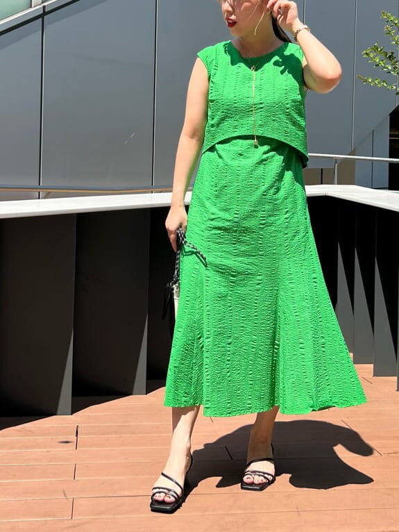 ブラック系のショルダーバッグ、グリーン系のワンピース、ブラック系のサンダルを着用したレディースの夏コーディネートの4枚目の写真