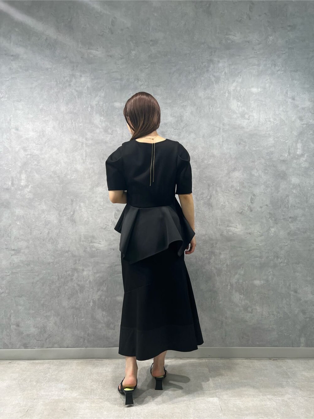 ブラック系のスカート、ブラック系のサンダル、ブラック系のTシャツ/カットソーを着用したレディースの春コーディネートの2枚目の写真