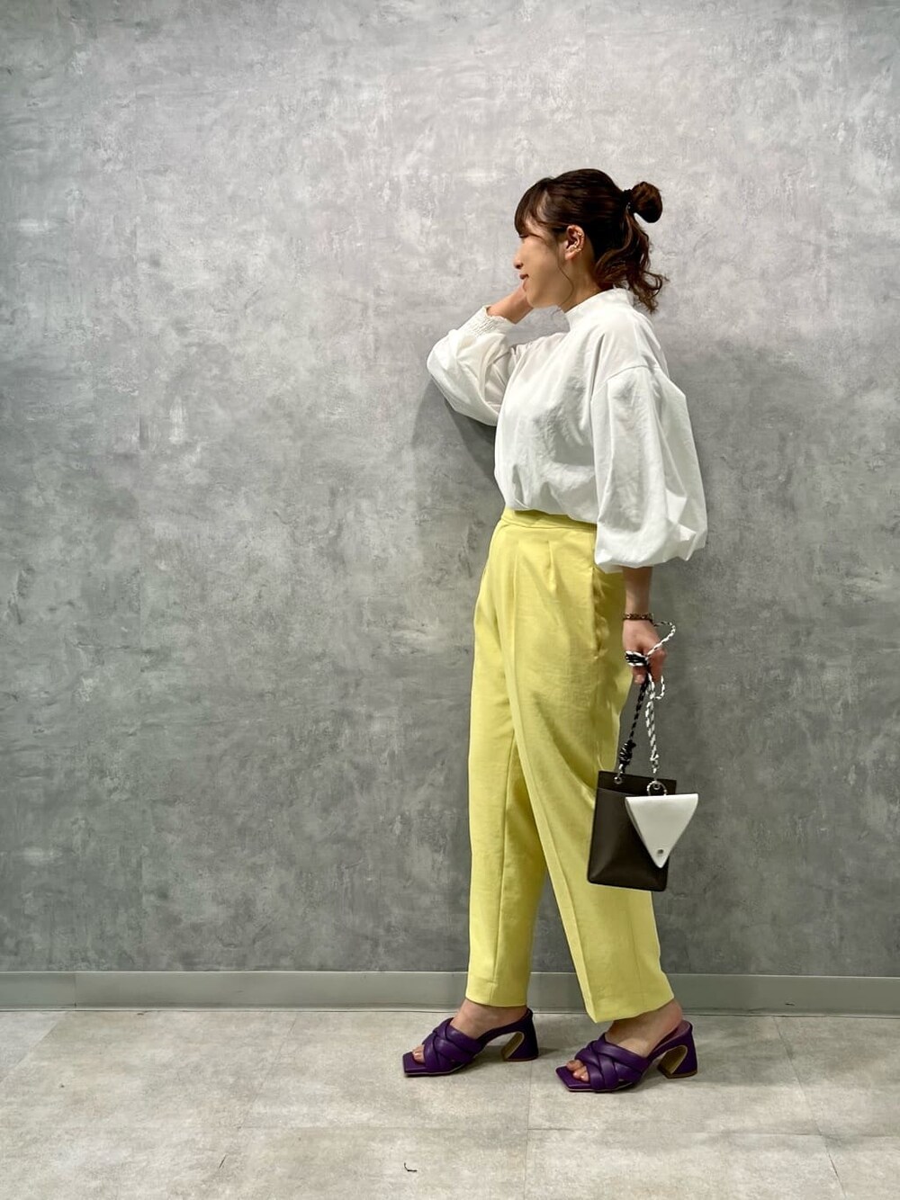 ベージュ系のショルダーバッグ、イエロー系のその他パンツ、パープル系のサンダルを着用したレディースの春コーディネートの2枚目の写真