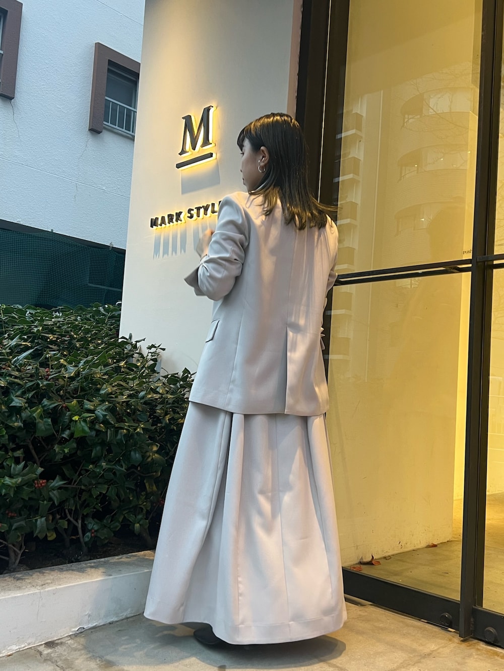 ベージュ系のテーラードジャケット、ベージュ系のワンピース、ブラック系のブーツを着用したレディースの冬コーディネートの3枚目の写真