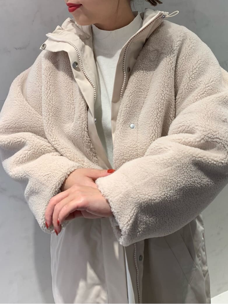 ホワイト系のモッズコート、ホワイト系のスカート、ホワイト系のニット/セーターを着用したレディースの秋コーディネートの3枚目の写真