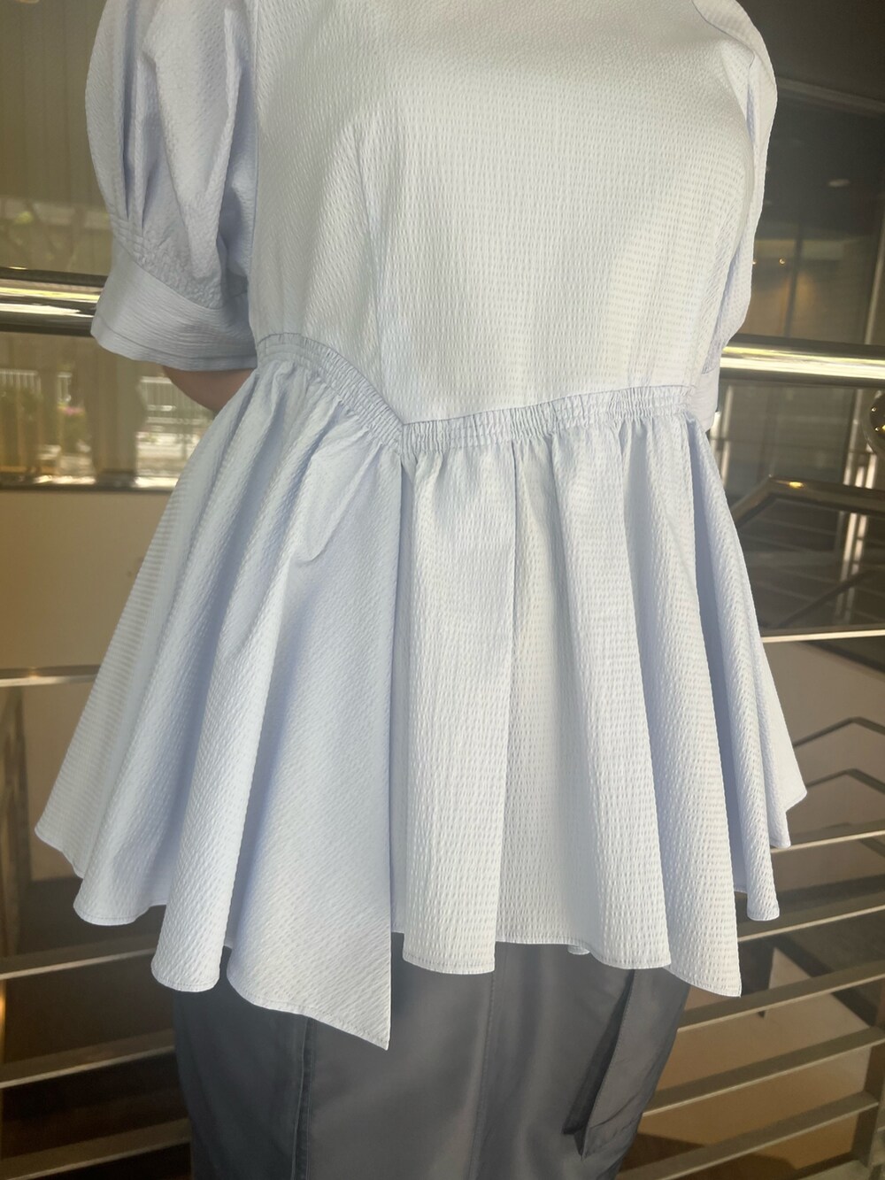 ブルー系のシャツ/ブラウス、ブルー系のスカート、ブラック系のブーツを着用したレディースの春コーディネートの5枚目の写真