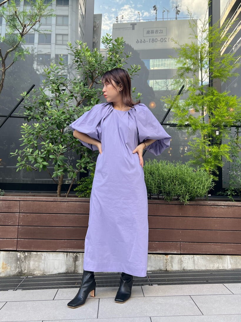 パープル系のワンピース、ブラック系のブーツ、ブラック系のベルトを着用したレディースの夏コーディネートの4枚目の写真