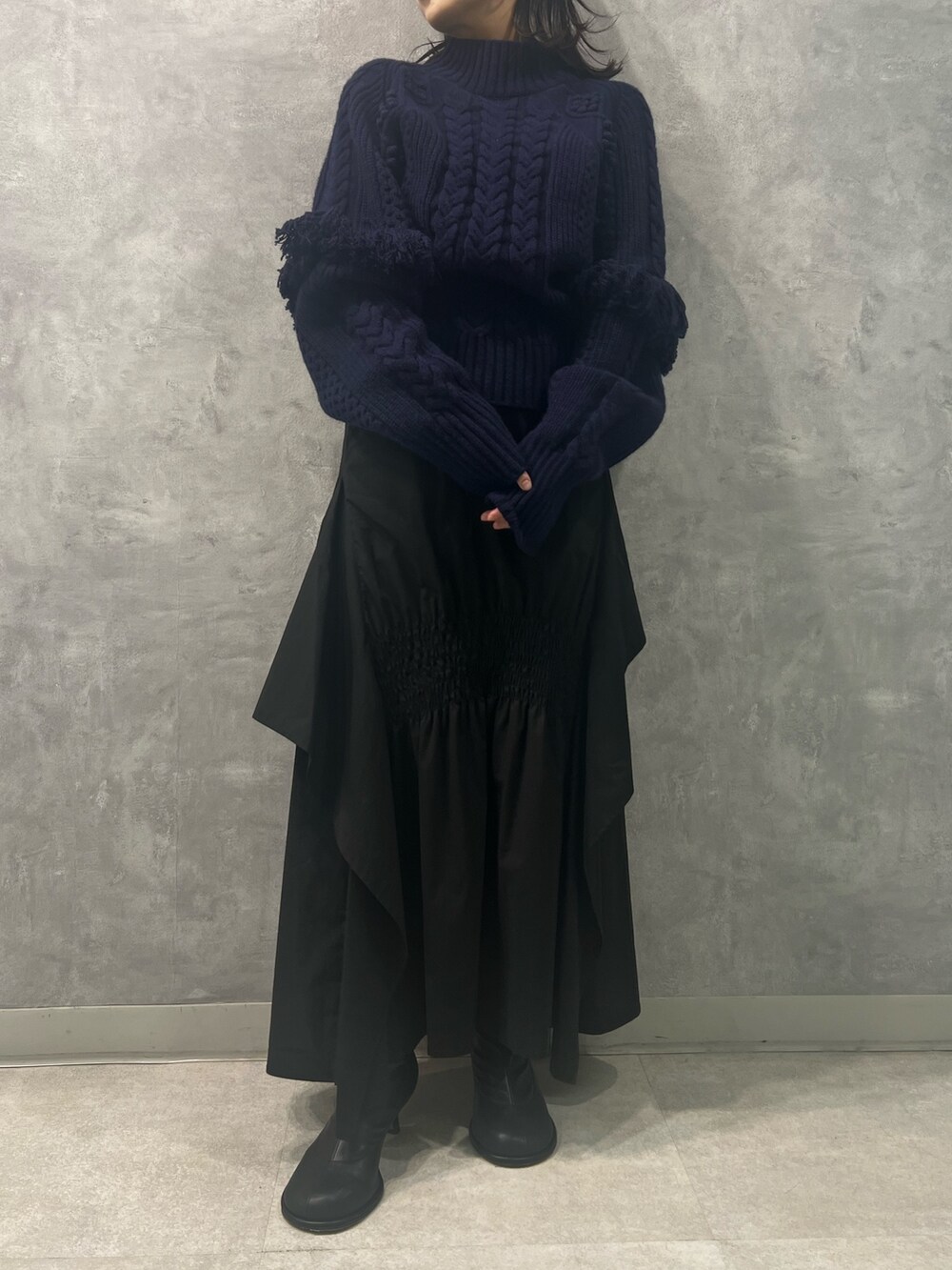 ブラック系のスカート、ブルー系のニット/セーターを着用したレディースの春コーディネートの5枚目の写真