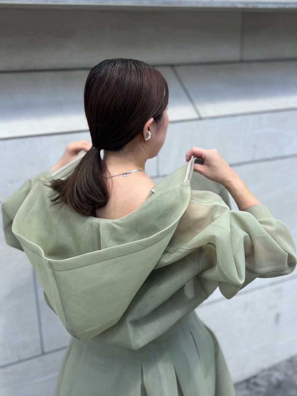グリーン系のスカート、グリーン系のブルゾン、その他のパンプスを着用したレディースの夏コーディネートの6枚目の写真