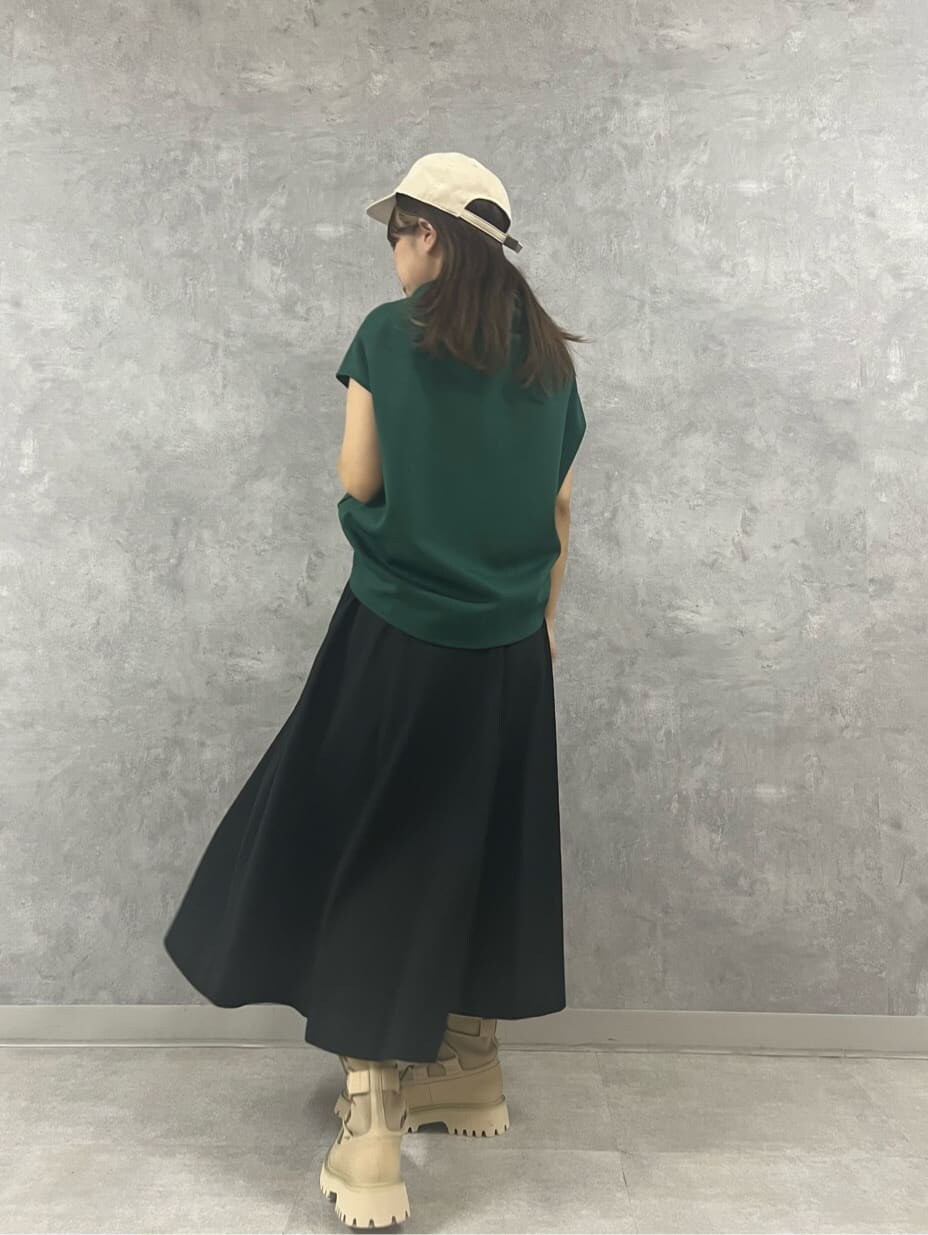 グリーン系のTシャツ/カットソー、ブラック系のスカート、ホワイト系のキャップを着用したレディースの夏コーディネートの5枚目の写真