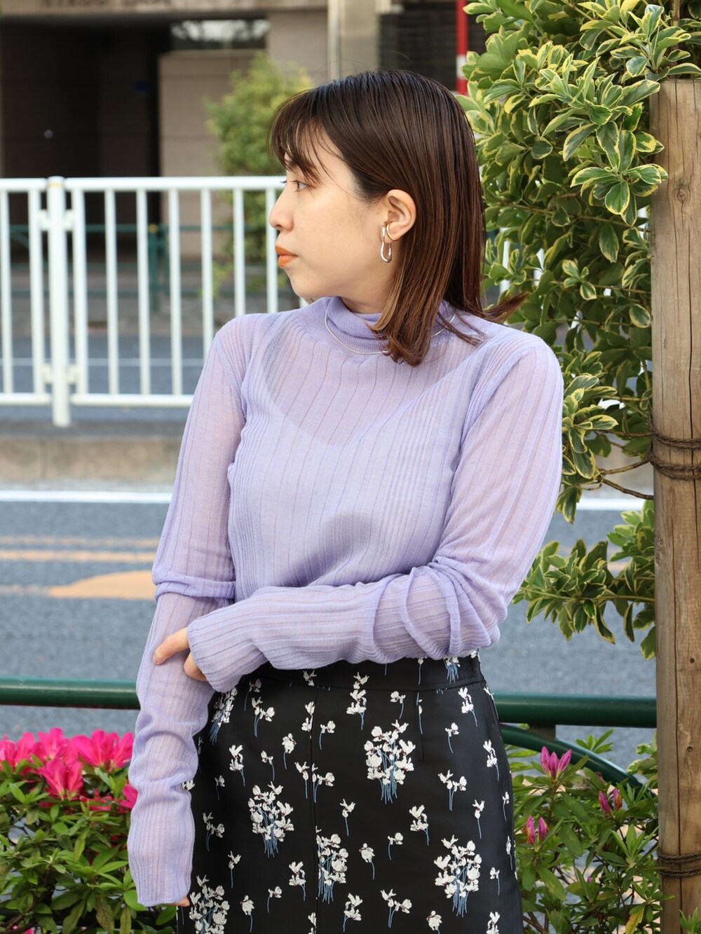 ブラック系のブーツ、パープル系のニット/セーター、ブラック系のスカートを着用したレディースの春コーディネートの3枚目の写真