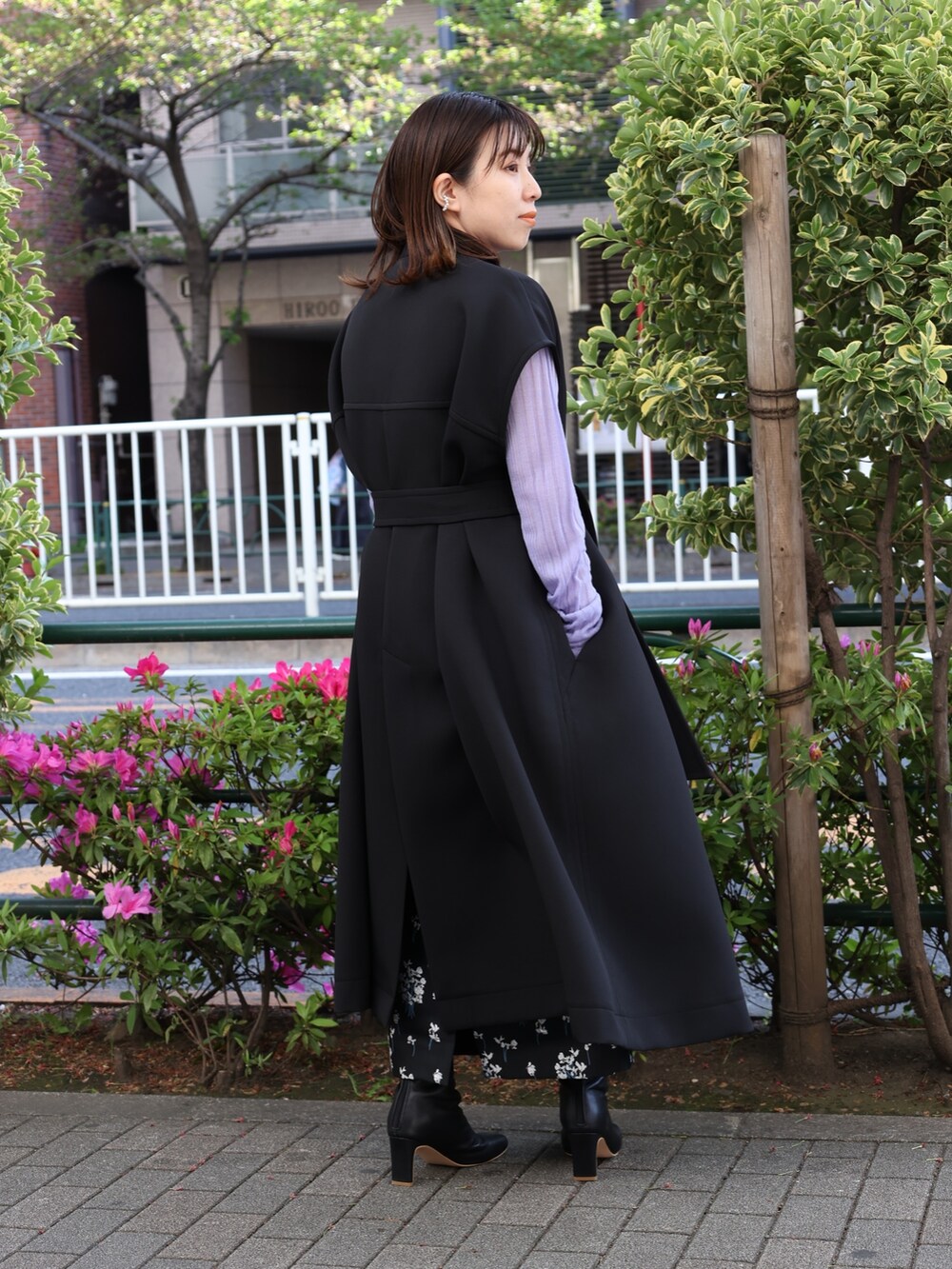 ブラック系のブーツ、パープル系のニット/セーター、ブラック系のスカートを着用したレディースの春コーディネートの4枚目の写真