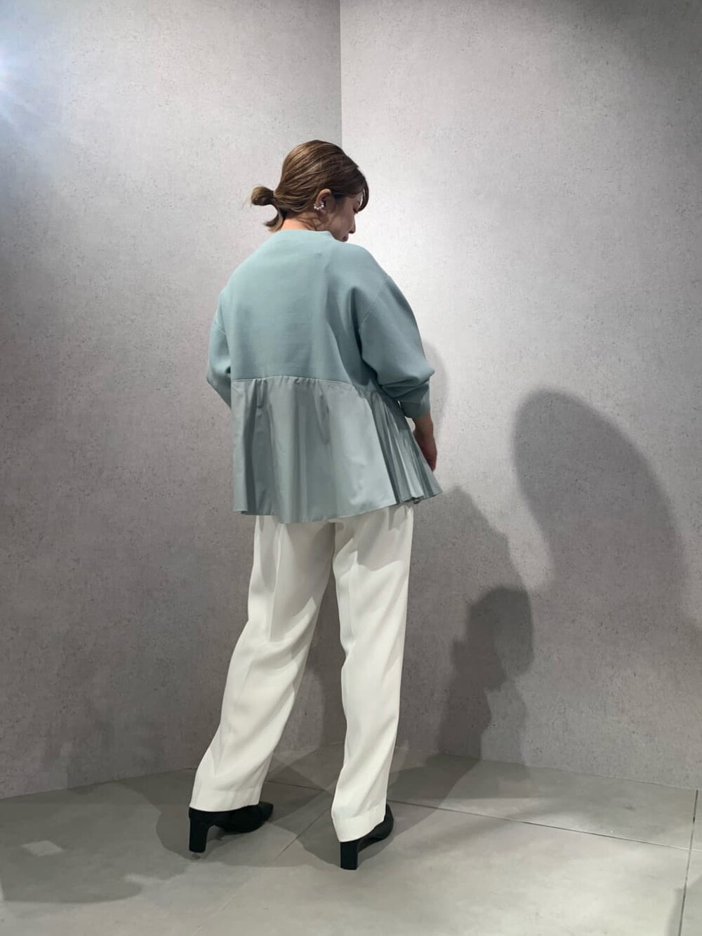 ホワイト系のその他パンツ、ブラック系のブーツ、ブルー系のニット/セーターを着用したレディースの秋コーディネートの4枚目の写真