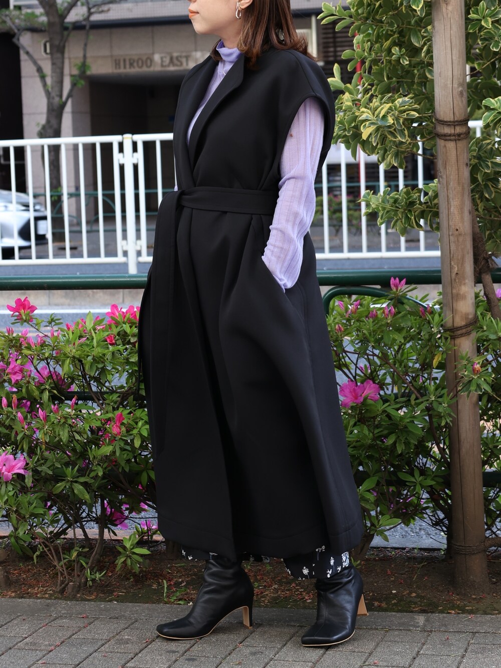 ブラック系のブーツ、パープル系のニット/セーター、ブラック系のスカートを着用したレディースの春コーディネートの5枚目の写真