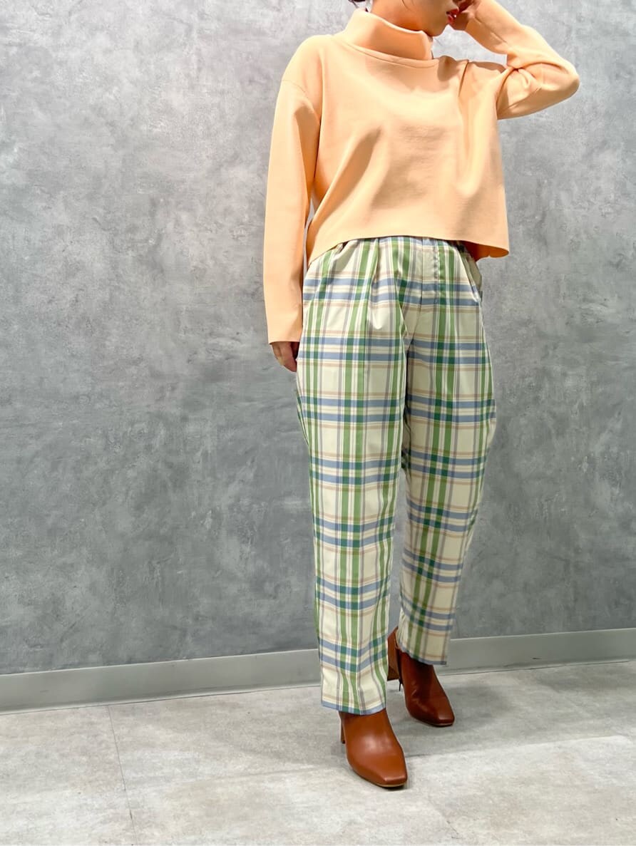 ブラウン系のブーツ、グリーン系のその他パンツ、オレンジ系のニット/セーターを着用したレディースの冬コーディネートの2枚目の写真