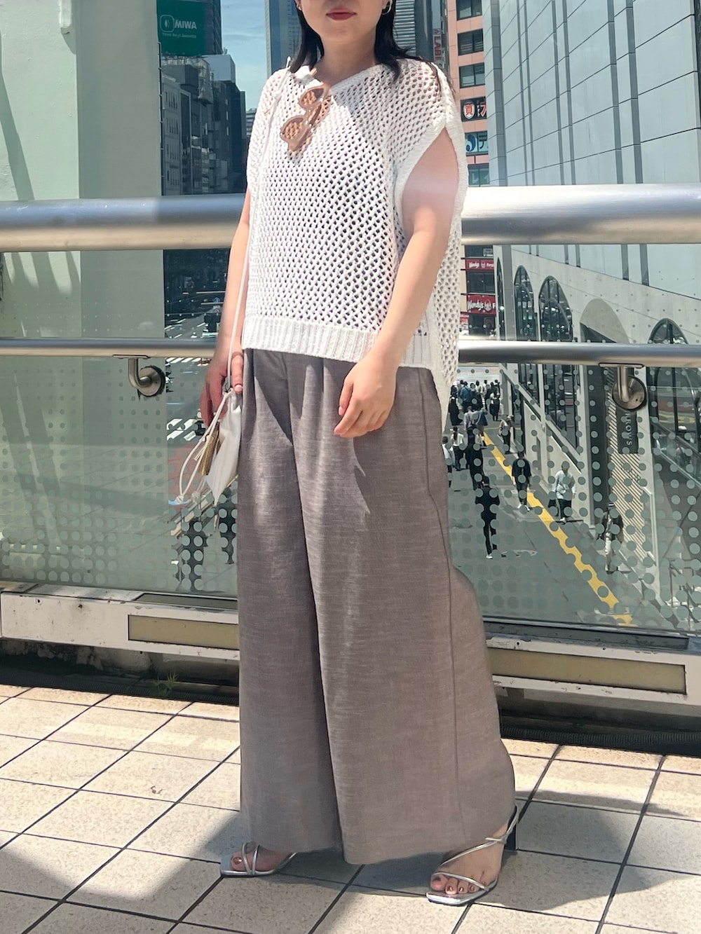 ホワイト系のニット/セーター、ブラウン系のその他パンツ、ホワイト系のショルダーバッグを着用したレディースの夏コーディネートの3枚目の写真