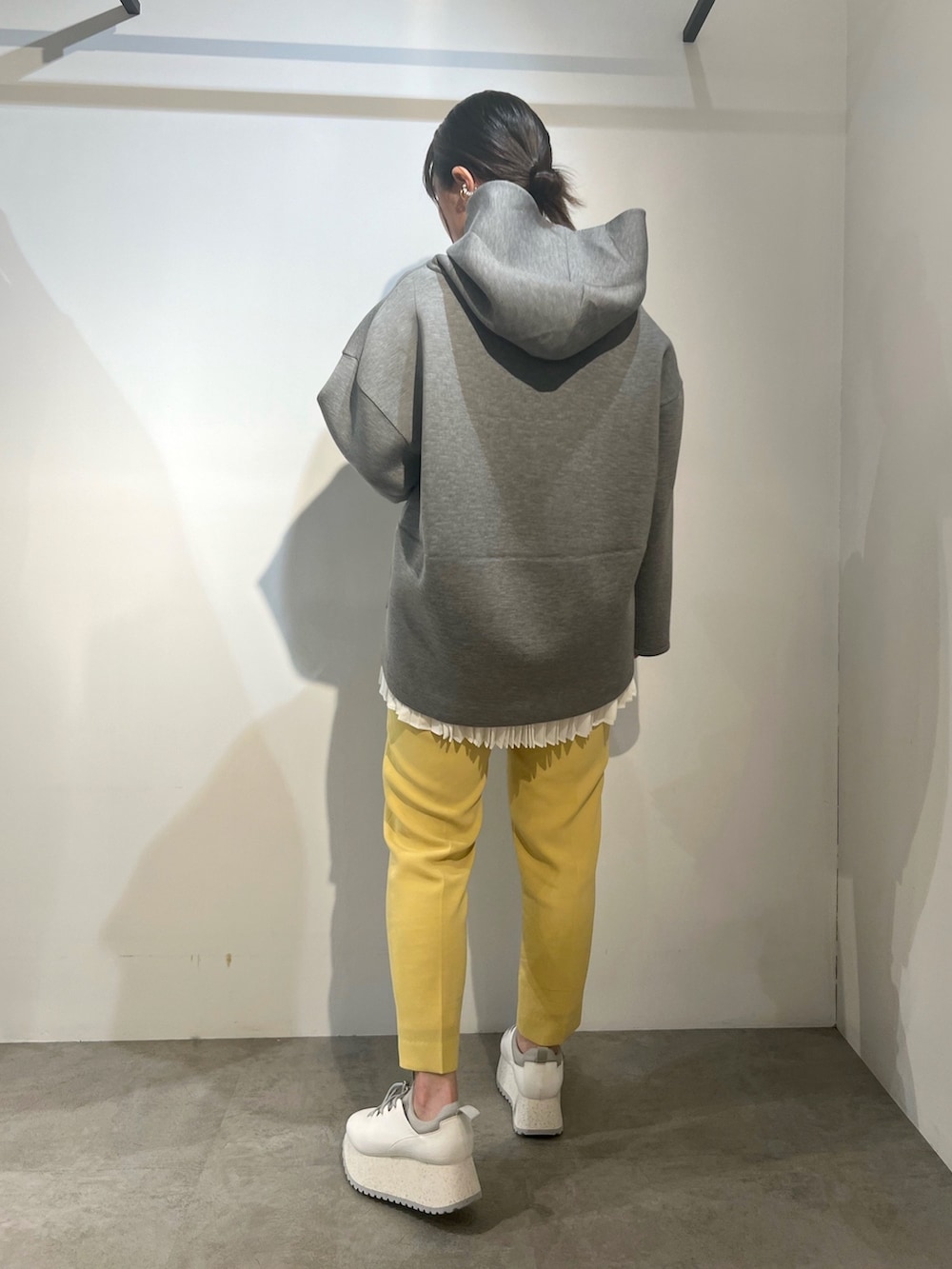 ホワイト系のスニーカー、グレー系のパーカー、イエロー系のその他パンツを着用したレディースの冬コーディネートの2枚目の写真