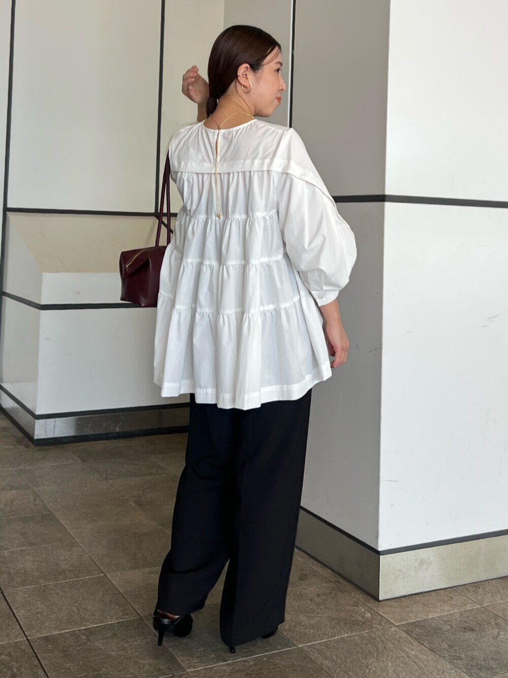 ホワイト系のシャツ/ブラウス、ブラック系のその他パンツ、レッド系のボストンバッグを着用したレディースの秋コーディネートの2枚目の写真