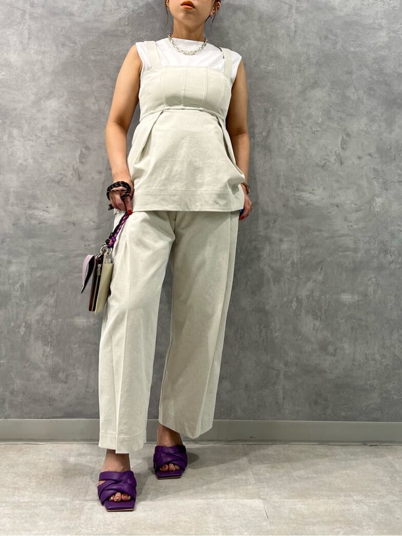 ホワイト系のタンクトップ、ベージュ系のキャミソール、パープル系のサンダルを着用したレディースの春コーディネートの3枚目の写真