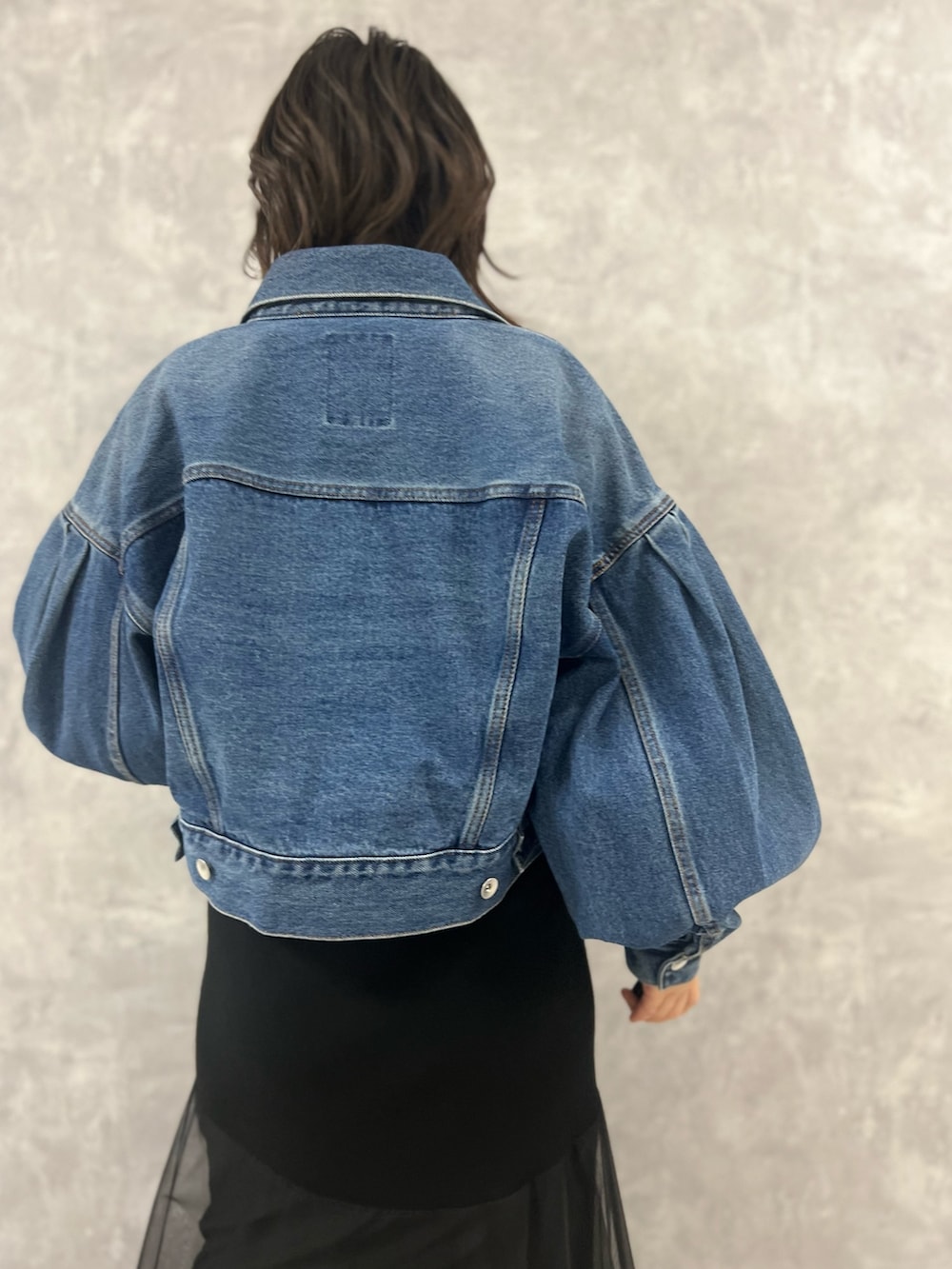 ブラック系のワンピース、ブルー系のデニムジャケット、ベージュ系のショルダーバッグを着用したレディースの冬コーディネートの4枚目の写真