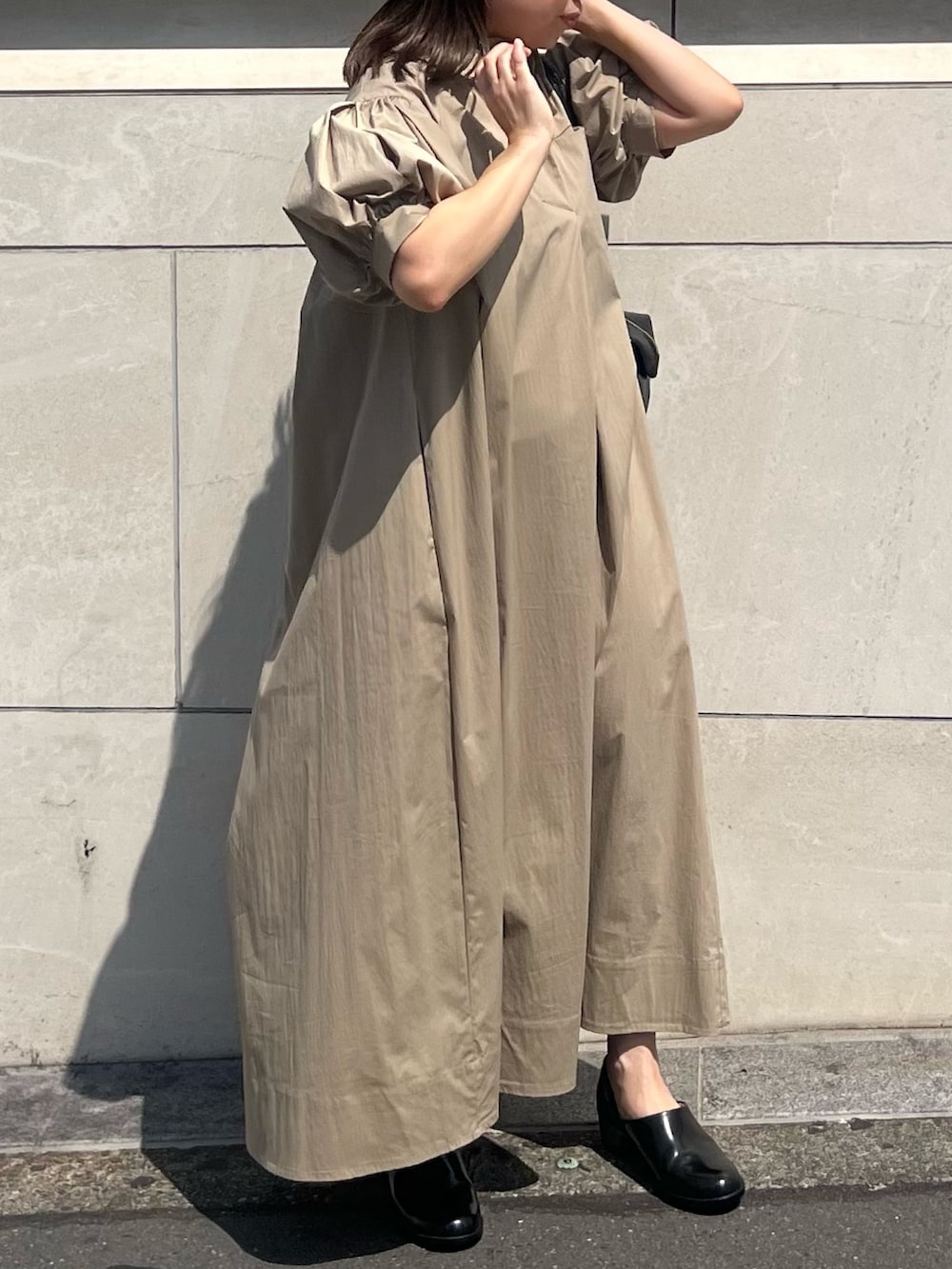 ベージュ系のワンピース、ブラック系のボストンバッグ、ブラック系のパンプスを着用したレディースの夏コーディネートの4枚目の写真