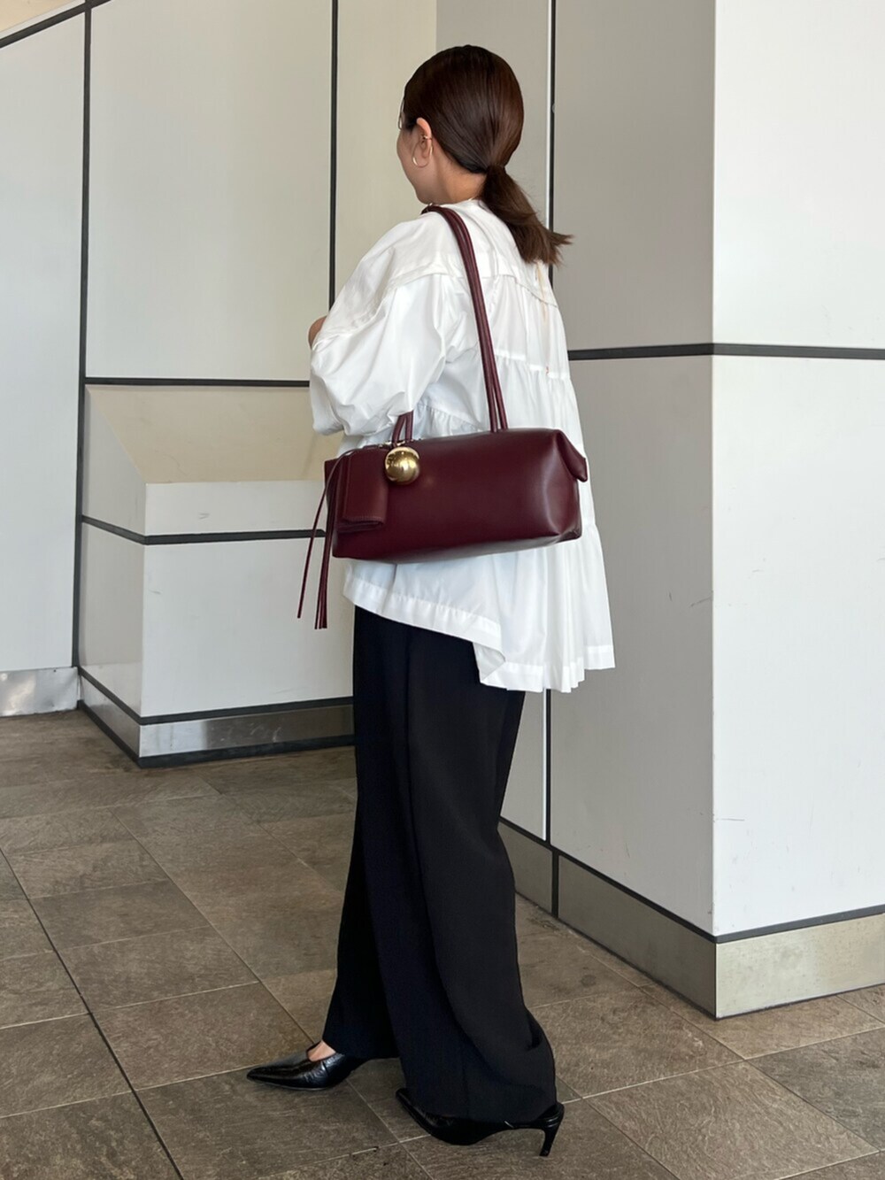 ホワイト系のシャツ/ブラウス、ブラック系のその他パンツ、レッド系のボストンバッグを着用したレディースの秋コーディネートの3枚目の写真
