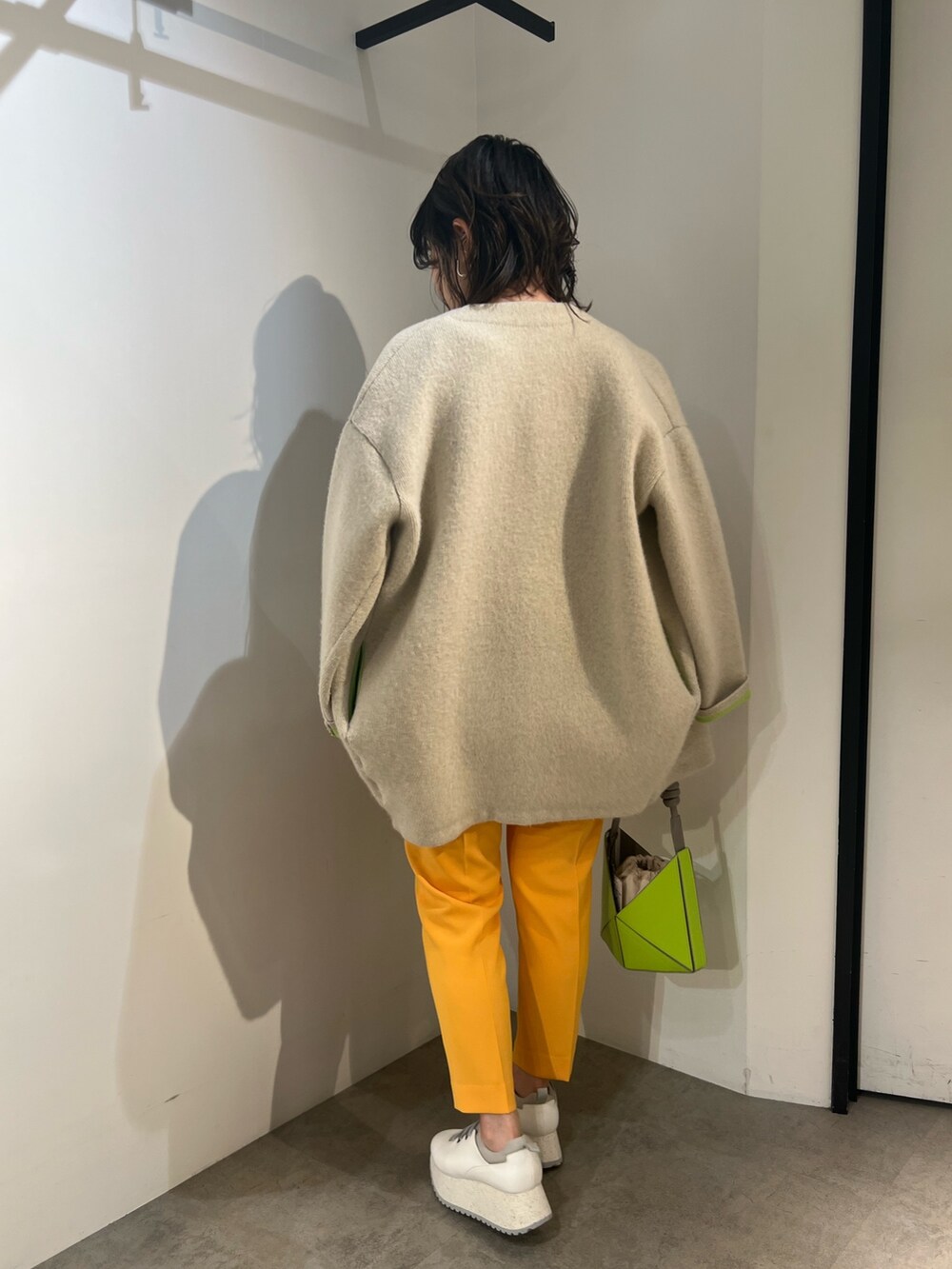 ホワイト系のシャツ/ブラウス、ホワイト系のカーディガン/ボレロ、イエロー系のハンドバッグを着用したレディースの冬コーディネートの3枚目の写真