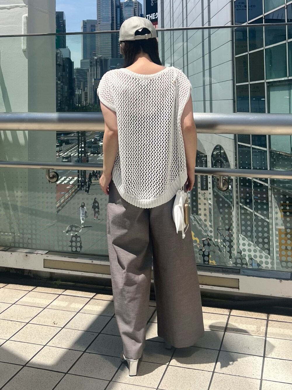 ホワイト系のニット/セーター、ブラウン系のその他パンツ、ホワイト系のショルダーバッグを着用したレディースの夏コーディネートの6枚目の写真