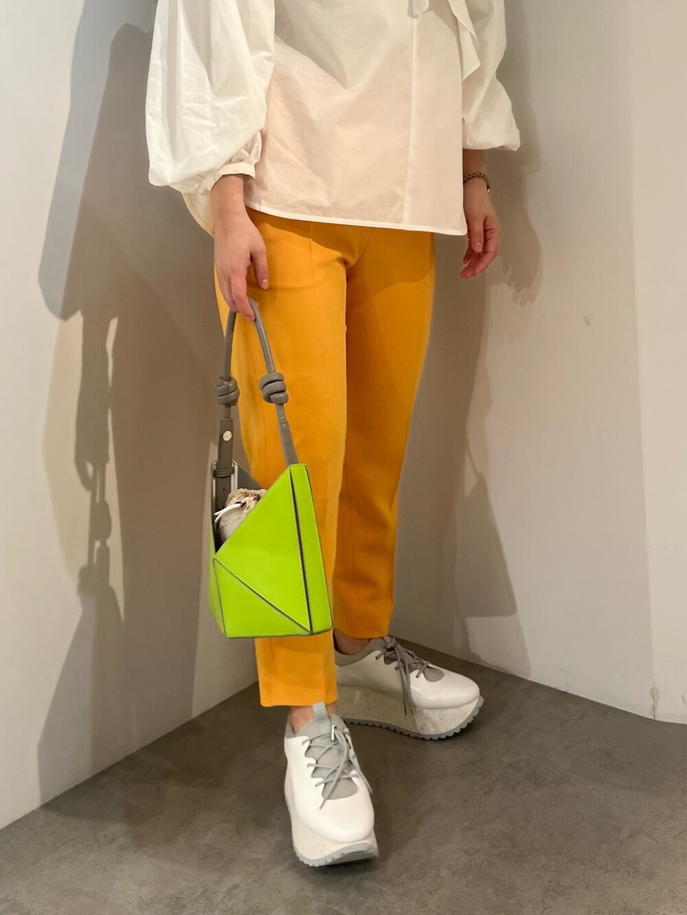 ホワイト系のシャツ/ブラウス、イエロー系のハンドバッグ、オレンジ系のその他パンツを着用したレディースの冬コーディネートの4枚目の写真