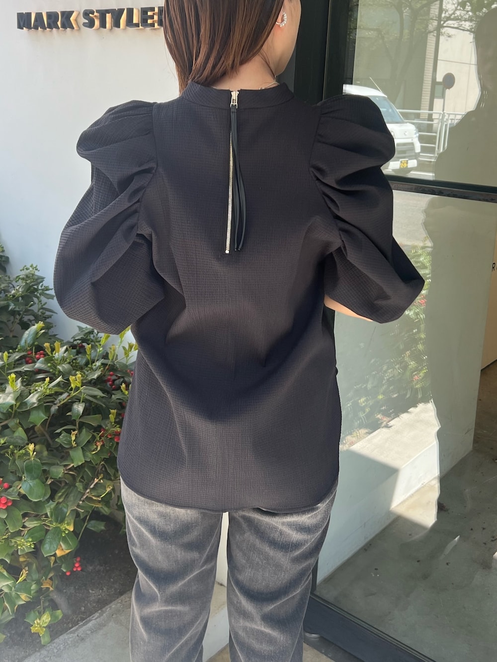 ブラック系のシャツ/ブラウス、グレー系のデニムパンツ、ブラック系のパンプスを着用したレディースの春コーディネートの3枚目の写真