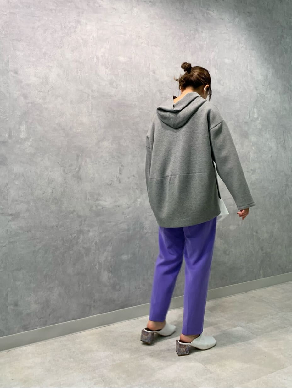 ホワイト系のサンダル、パープル系のスラックス、グレー系のパーカーを着用したレディースの秋コーディネートの2枚目の写真